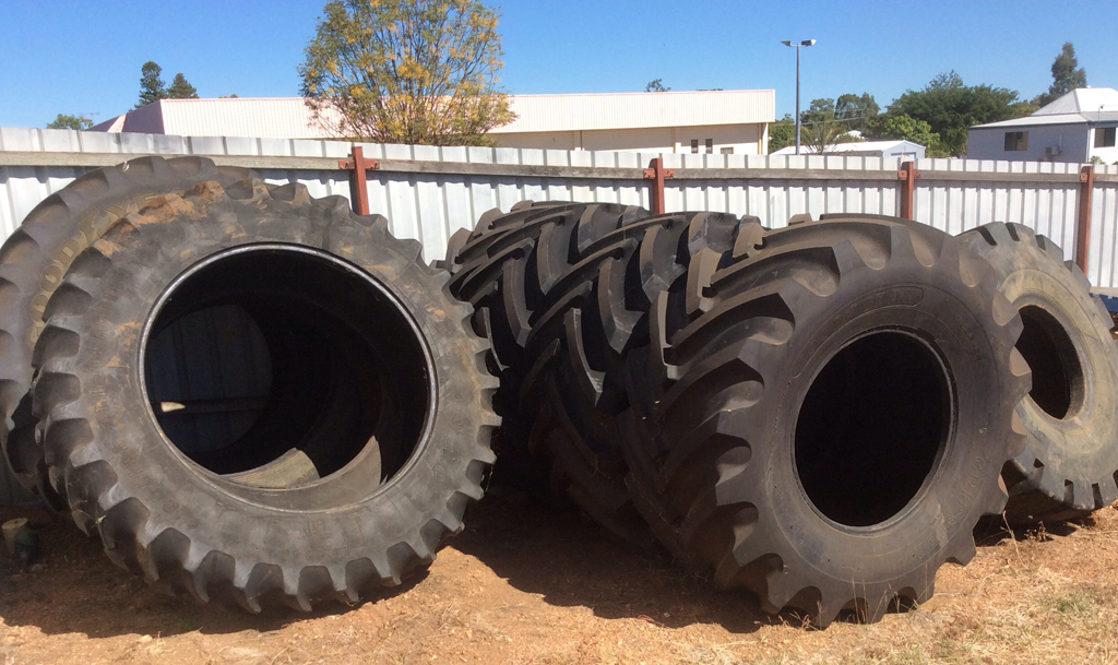 A row of large tractor and floatation tyres standing in the yard at Purdie's Tyres